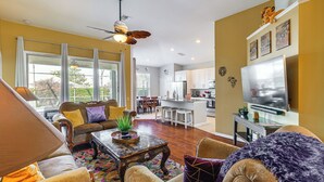 A spacious living area with a sofa, armchair, coffee table, and a ceiling fan. - Pool, Themed Rooms & Arcade: Disney Escape (Kissimmee)