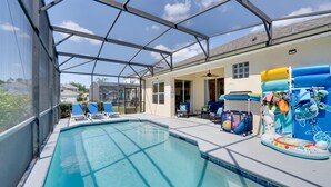 An indoor swimming pool with clear blue water, surrounded by lounge chairs and a poolside area with a covered patio. - Pool, Themed Rooms & Arcade: Disney Escape (Kissimmee)