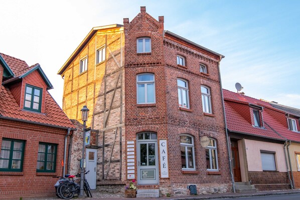 A brick building with a sign reading "CAFÉ" and a bicycle parked outside.