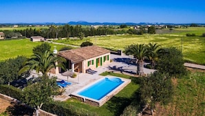 A villa with a swimming pool, surrounded by lush greenery and a clear view of distant mountains. - Villa Marina (Campos)