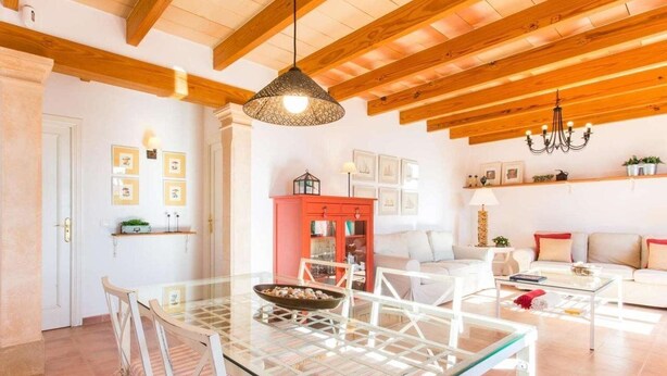 A spacious living area with a glass dining table, white sofas, and a red cabinet. - Villa Marina (Campos)
