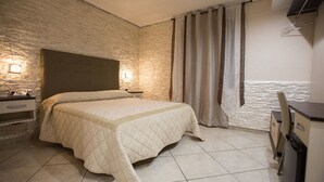 A bedroom with a bed, a nightstand, a lamp, a wardrobe, and a curtain. - La Fenice (Boscoreale)
