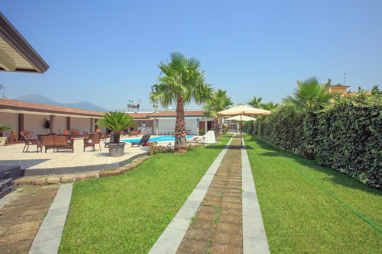 A well-maintained outdoor area with a swimming pool, lounge chairs, and a neatly trimmed hedge.