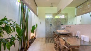 A modern bathroom with a glass countertop, a shower area, and a view of the outdoors. - Romantic Jungle Villa, 1 BR, Ubud With Staff (Ubud)