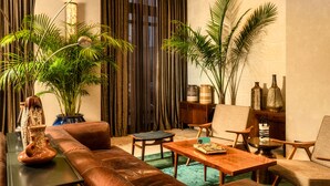Una sala de estar moderna con un sofá de cuero, una mesa de centro de madera y varias plantas.