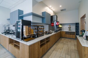 Un área de cocina moderna con encimera blanca, armarios de madera y salpicadero con motivo de espiga.