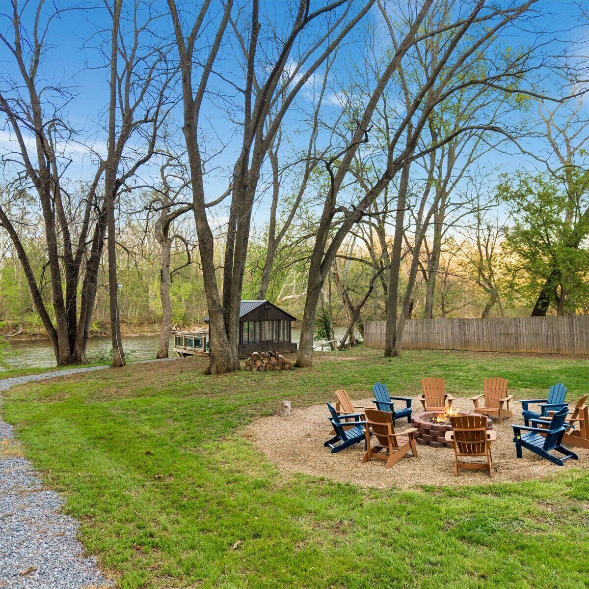 A backyard with a fire pit, outdoor furniture, a shed, and a wooden fence.