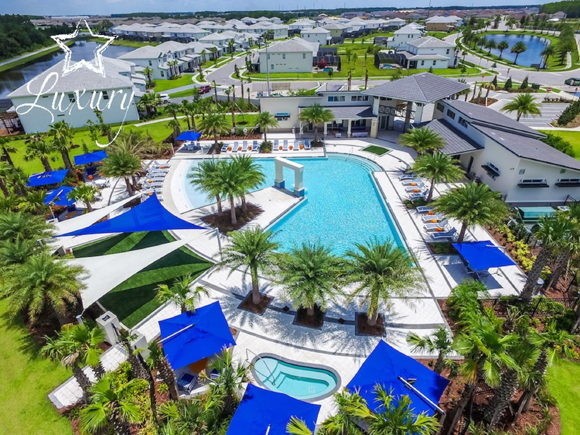 A luxury resort with a large central pool, multiple smaller pools, and a well-maintained landscape with palm trees and blue canopies.