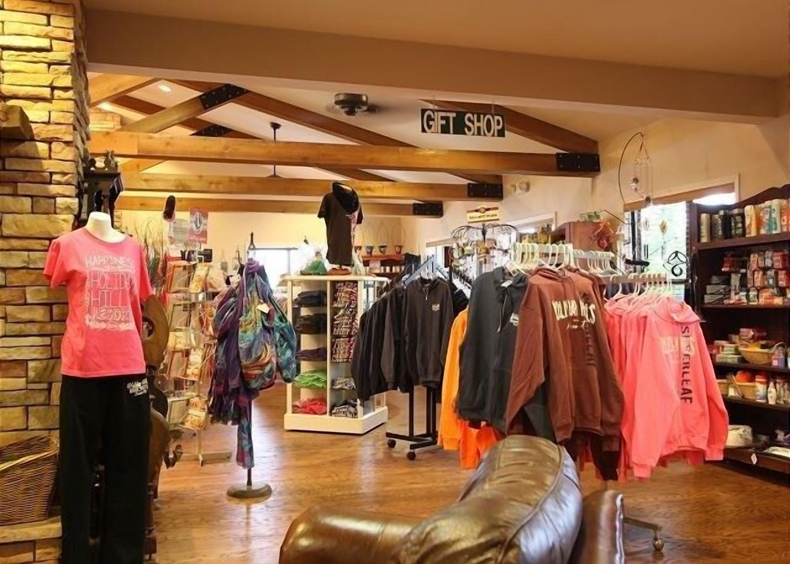 A gift shop with various clothing items on display, including t-shirts and hoodies.