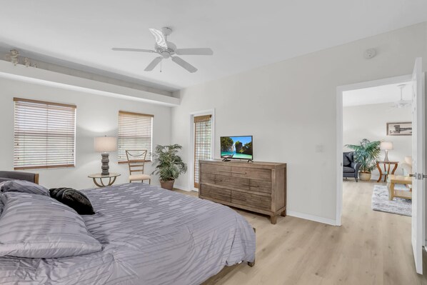 A bedroom with a bed, a dresser, a TV, and a ceiling fan. - Beautiful Corner Unit in Woods Edge W/ Brand New Kitchen, Community Pool -Close to Beach (Bonita Springs)