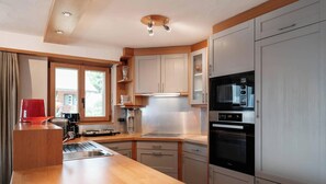 A modern kitchen with a stainless steel sink, a microwave, and a built-in oven.
