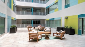 Relax in a spacious outdoor area with a central seating area and large windows offering views of the surrounding area.