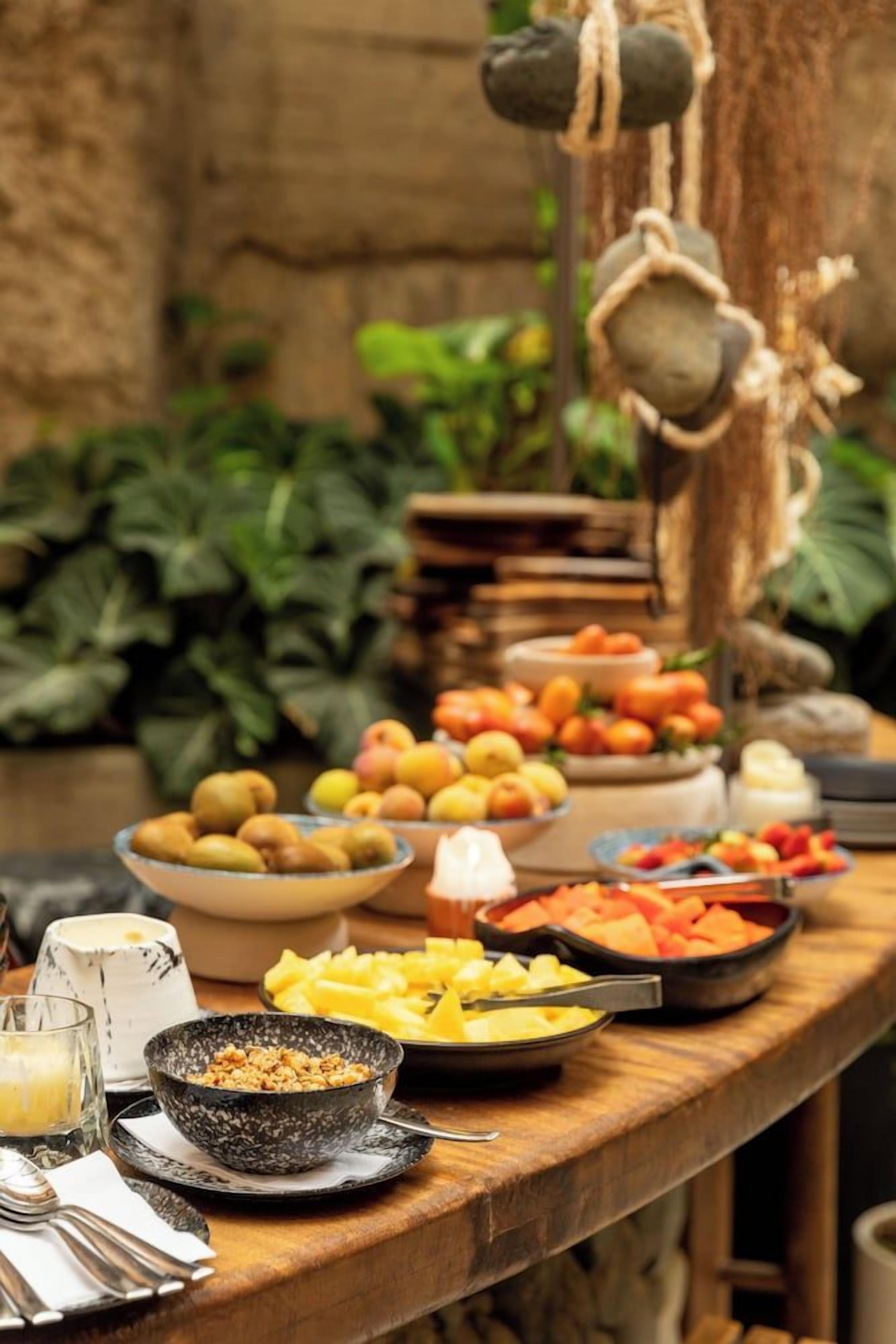 A buffet table with various fruits and dishes.