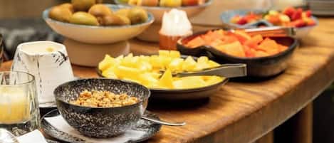 Una mesa de buffet con diversas frutas y platos.