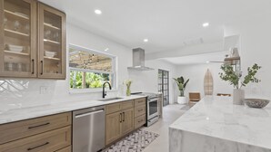 Una cocina moderna con armarios de madera, electrodomésticos de acero inoxidable y encimera de mármol.