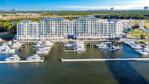 Een groot hotel met meerdere verdiepingen en een jachthaven met talloze boten.