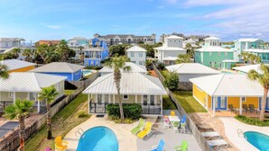 A resort with colorful buildings, a swimming pool, and outdoor seating areas. - Destined for Fun, House, Cabana, Pool + few steps to beach (Destin)