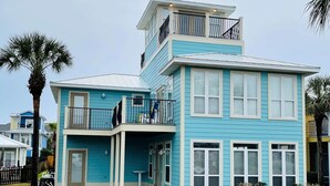 A two-story house with a balcony and a covered entryway. - Destined for Fun, House, Cabana, Pool + few steps to beach (Destin)