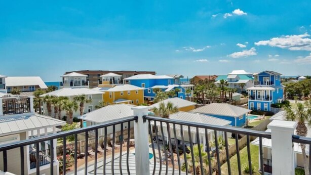 A coastal residential area with colorful houses, a clear sky, and a visible pool. - Destined for Fun, House, Cabana, Pool + few steps to beach (Destin)