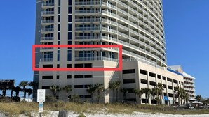 A high-rise hotel with multiple balconies and a parking garage.