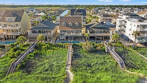 A coastal residential area with houses, a dock, and a pathway leading to a pool.