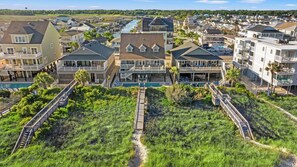 Un quartier résidentiel situé sur la côte, avec des maisons, un quai et un sentier menant à une piscine.