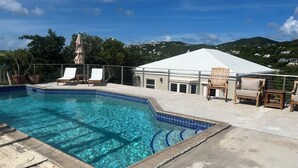 A swimming pool with clear blue water, surrounded by lounge chairs and a covered seating area. - Breezy Hilltop, Hart Bay View, only minutes from town (Cruz Bay)