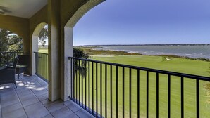 A balcony with a view of a golf course and a body of water. - 3 Bdrm Waterfront Villa in Harbour Town- Relax to the sounds of the Calibogue (Hilton Head Island)