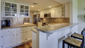 A kitchen with white cabinetry, a stainless steel refrigerator, a microwave, and a toaster. - 3 Bdrm Waterfront Villa in Harbour Town- Relax to the sounds of the Calibogue (Hilton Head Island)