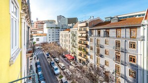 Une vue de rue avec des bâtiments, des voitures garées et un ciel dégagé.