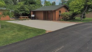 Un petit bâtiment d’un seul étage, doté d’un patio couvert, d’une table de pique-nique et d’un barbecue.
