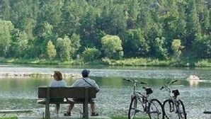 Un banc au bord d’un lac, avec des vélos garés à proximité.