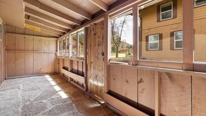 A room with wooden walls, large windows, and a stone floor. - Make Memories from your Deck - In Rapid City On Canyon Lake Thirty Minutes from Mt Rushmore (Rapid City)