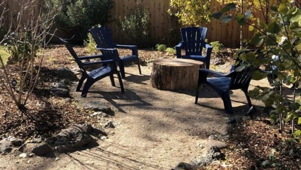 An outdoor seating area with four dark blue chairs and a round wooden table. - Percival`s Perch at The Judge Jones Historic Homes (Flagstaff)