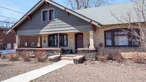 A two-story house with a gabled roof, a front porch, and a brick facade. - Percival`s Perch at The Judge Jones Historic Homes (Flagstaff)