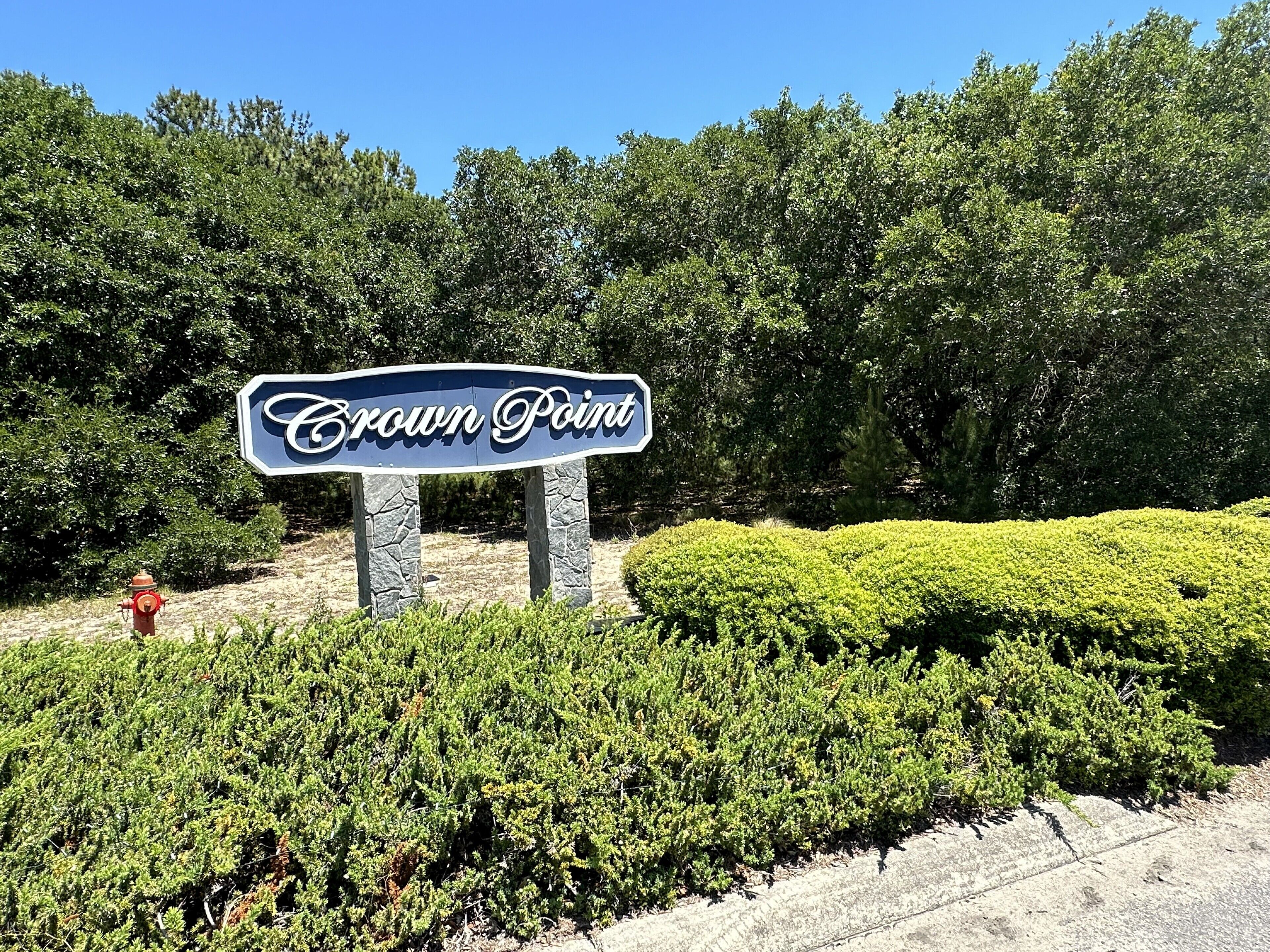 Un panneau indiquant l’entrée de Crown Point, avec un espace paysager aménagé devant.