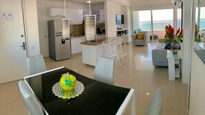 Een modern appartement met een eetgedeelte, keuken, woonkamer en balkon met uitzicht.