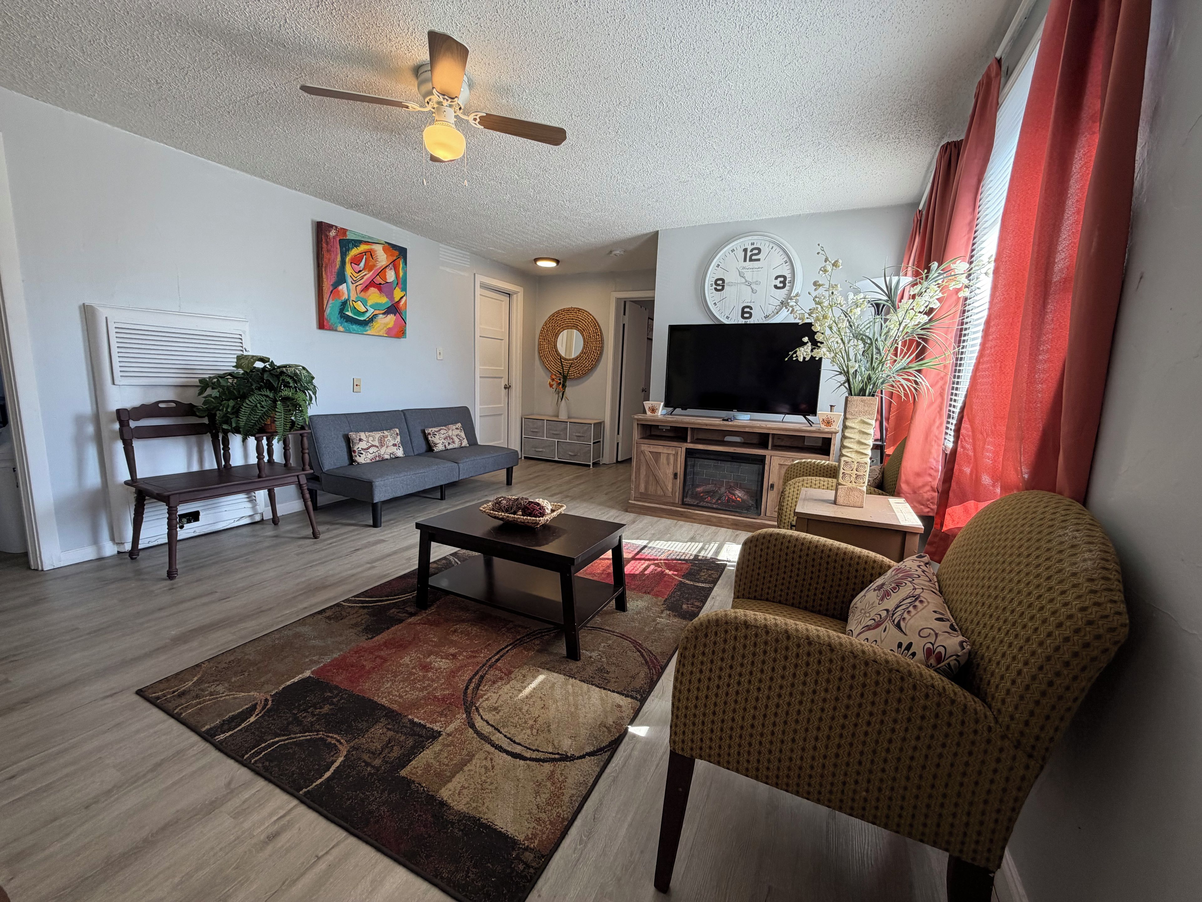 A living room with a sofa, a coffee table, a TV, and a fireplace.