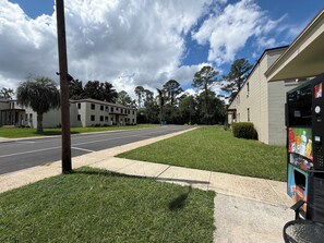 A street view with a building, a sidewalk, and a vending machine. - Historic Cozy Apartment near Hospital & VSU -SF (Valdosta)