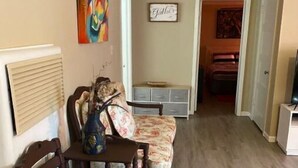 Ein Essbereich mit einem Holztisch, Stühlen, einer Vase und einem Bild an der Wand.