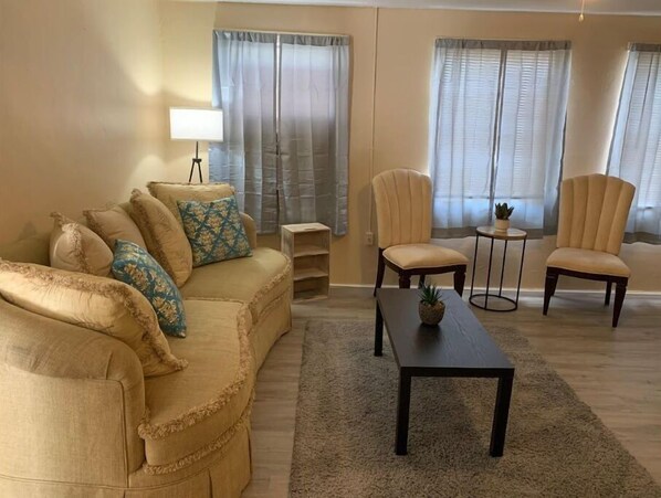 Cozy living room with a sofa, armchairs, and a floor lamp.