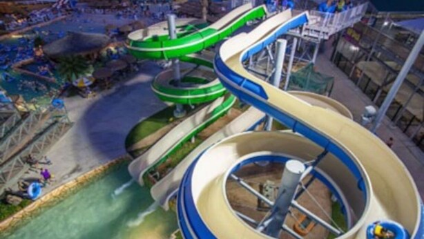 A water park with multiple water slides and a central circular pool.