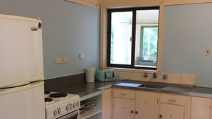 A small kitchen with a refrigerator, stove, oven, and a window with a view. - Perfect as a Falls Creek base camp. Pet friendly.  (Mount Beauty)