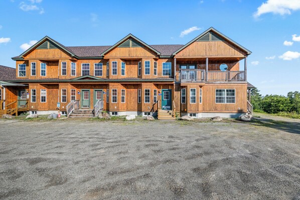 A large wooden two-story building with multiple windows and a balcony on the second floor.