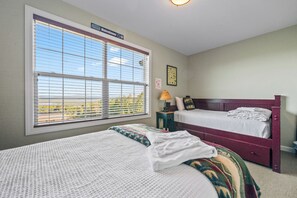A hotel room with two beds, a window with blinds, a nightstand, and a lamp. - Mountain Brook 152 - Ski in Ski out at Saddleback (Sandy River Plantation)