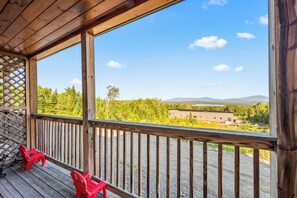 A wooden deck with a view of a forest and mountains. - Mountain Brook 152 - Ski in Ski out at Saddleback (Sandy River Plantation)