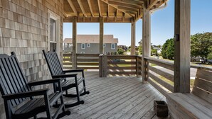 Eine Holzterrasse mit zwei Schaukelstühlen und einem Holzgeländer.