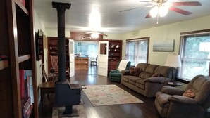 Ein gemütliches Wohnzimmer mit Kamin, einer Couch, einem Couchtisch und einem Bücherregal.