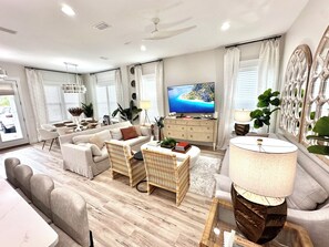 Una sala moderna con un conjunto de sofás, un televisor y un comedor.