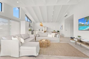 Relax in this stylish living room with a sectional sofa, round coffee table, and flat-screen TV.
